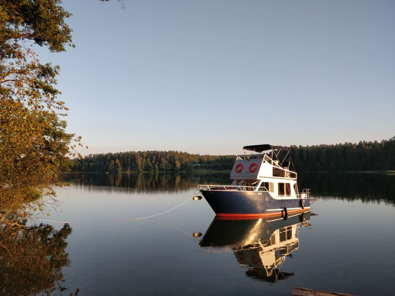 The boat reflected in mirror-still lake water at dusk